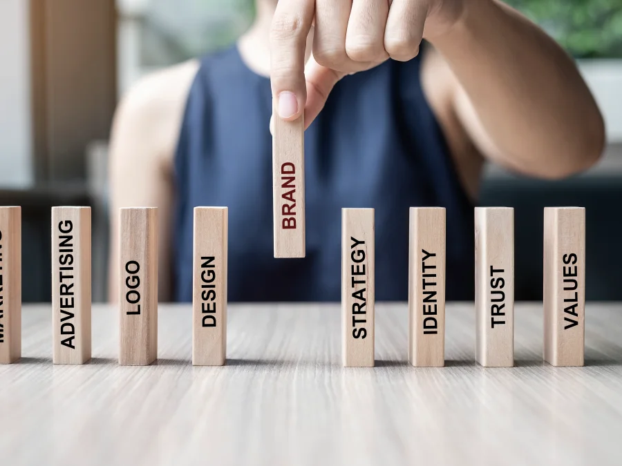 Wooden blocks labelled brand, design, strategy and trust being lined up