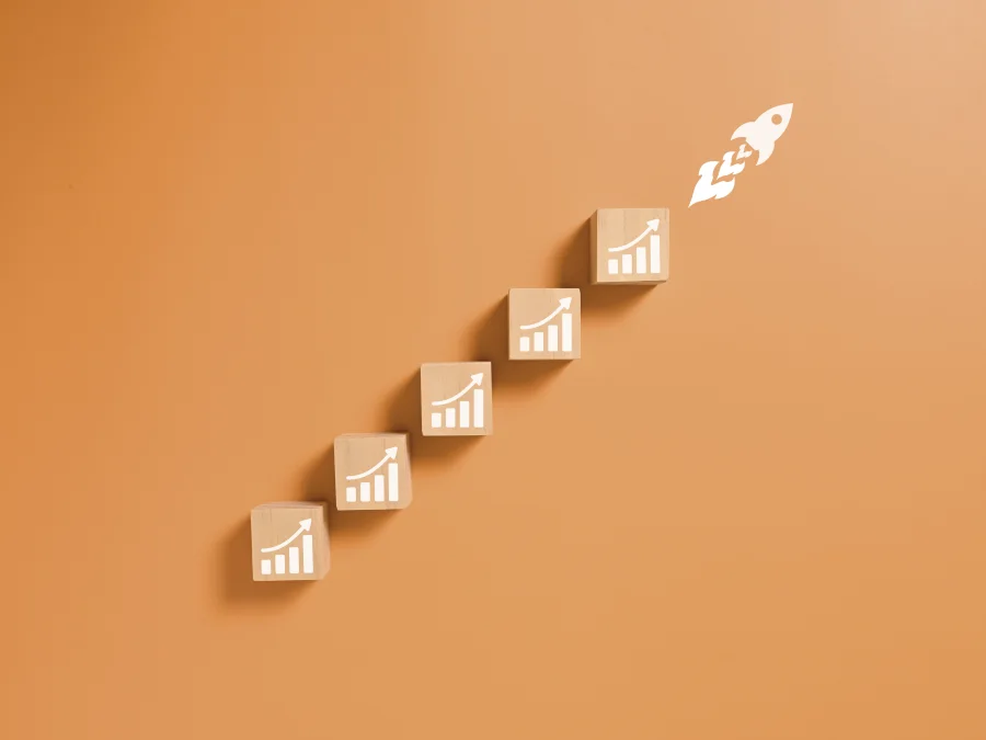 Wooden blocks with rising charts and a rocket taking off